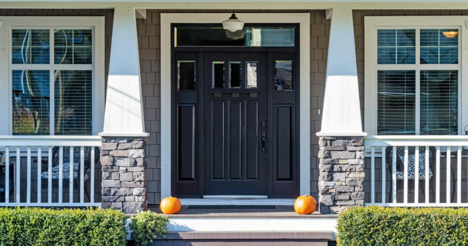 Front door of a house with a garden in front, and two decorative pumpkins representing new doors.