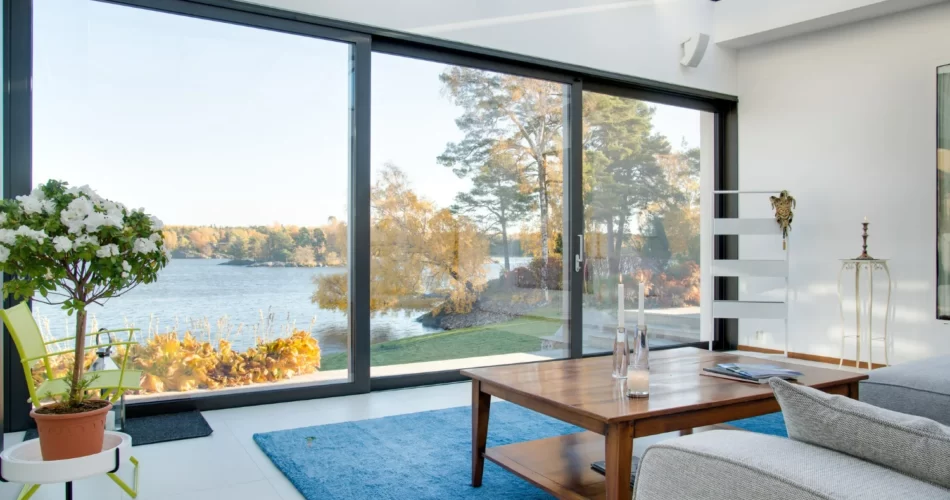 A living room with large fiberglass windows and a view of nature.
